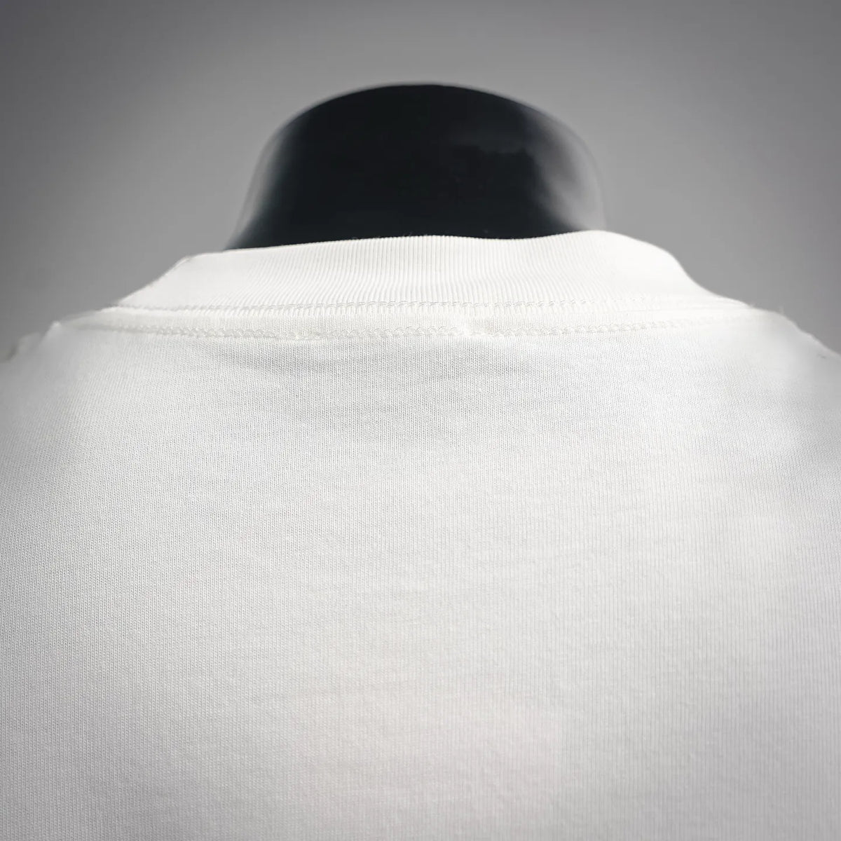 White T-shirt back close-up, crew collar and smooth fabric texture