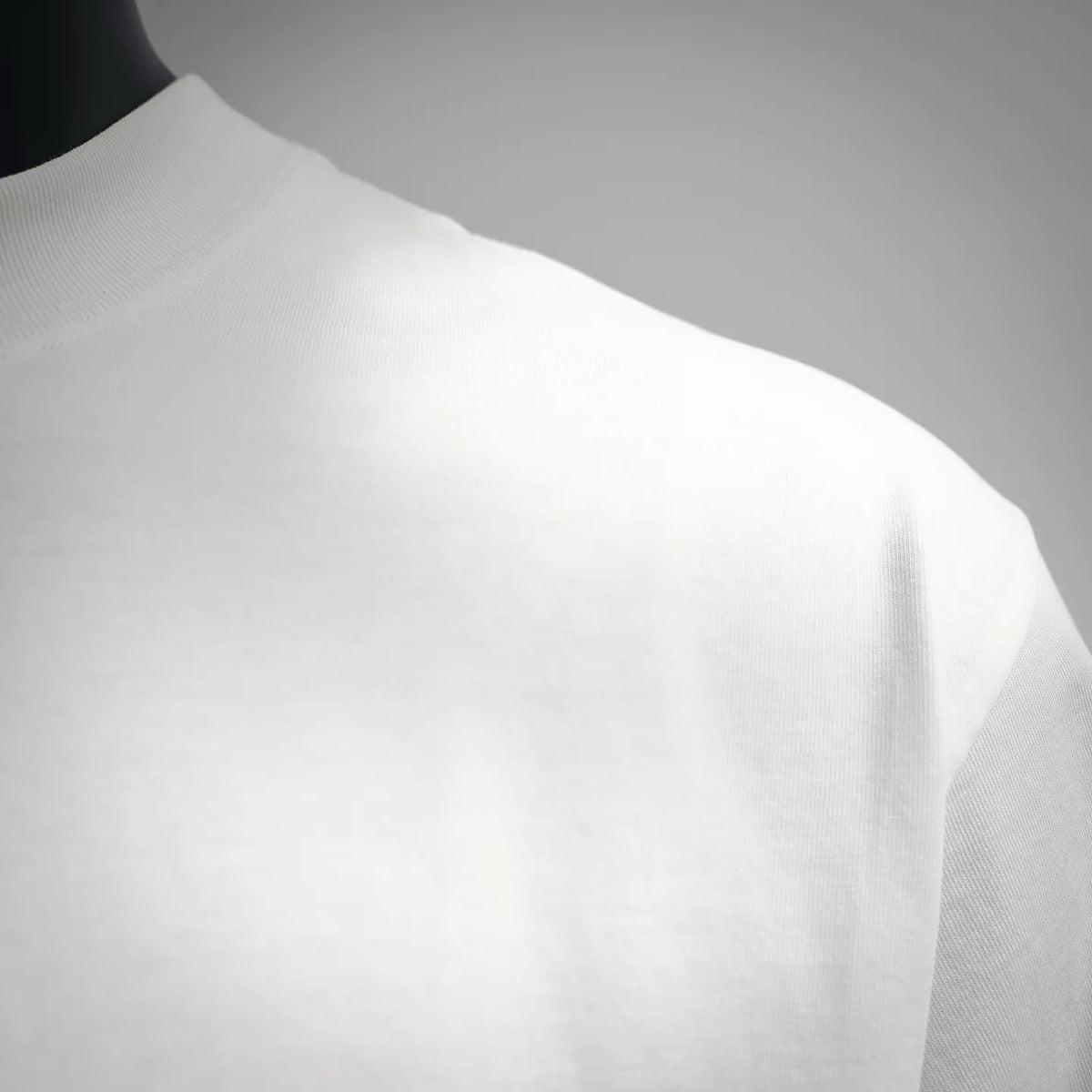 White short-sleeve T-shirt side view, smooth fabric and visible seam.