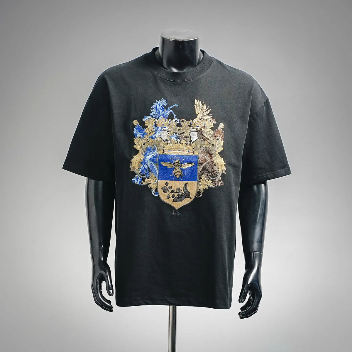 Black short-sleeve T-shirt with large blue and gold crest graphic on the front