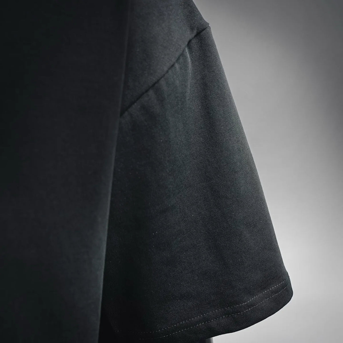 Black T-shirt sleeve corner with stitched hem detail