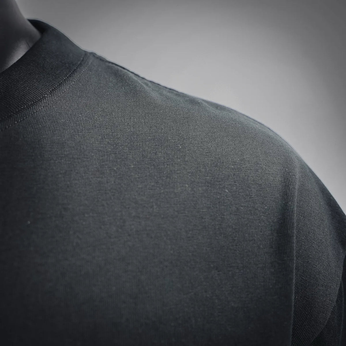Black T-shirt shoulder area with fabric texture and seam stitching