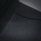 Black T-shirt fabric close-up showing seam stitching near the neckline