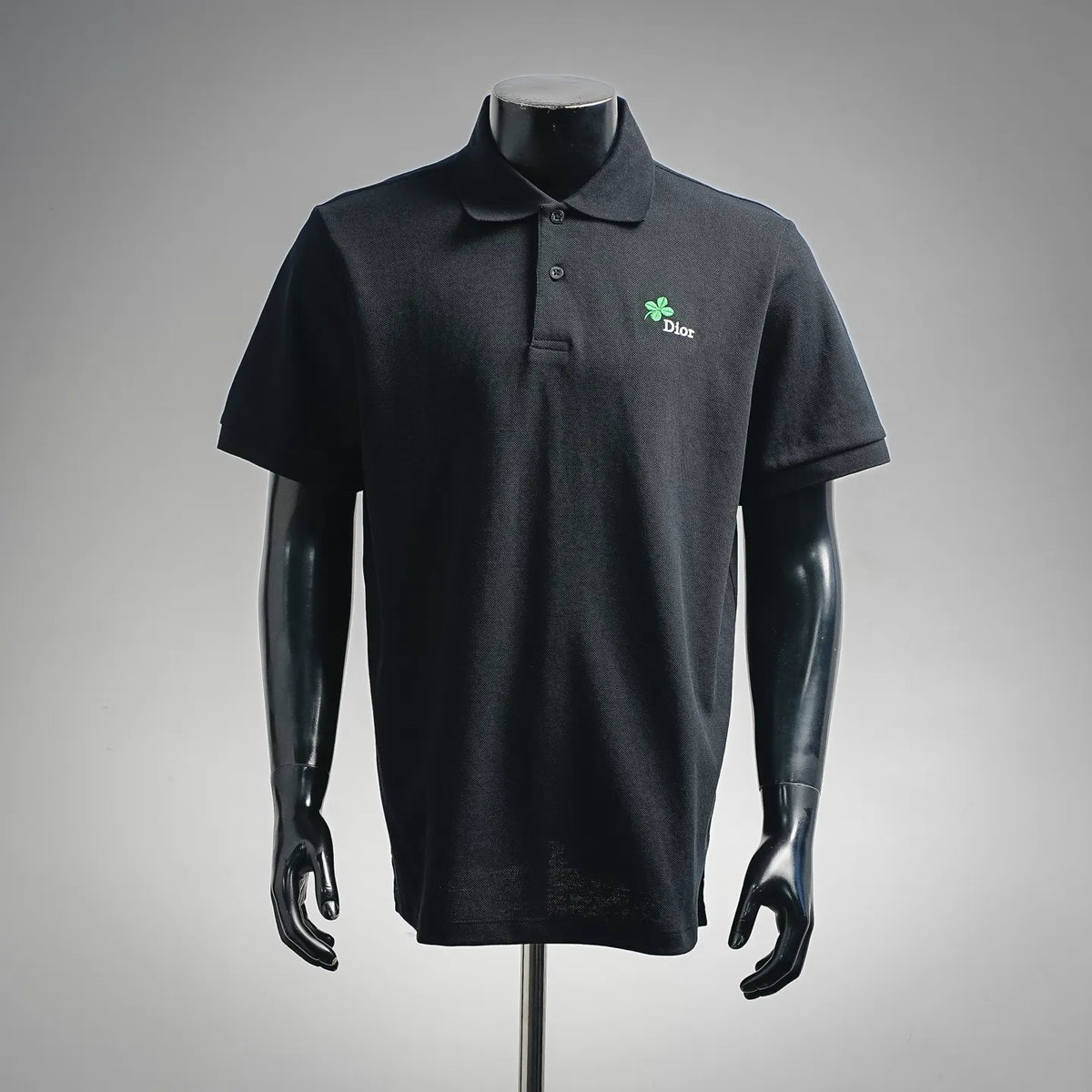 Dior polo shirt with buttoned collar, short sleeves, dark fabric, green clover logo