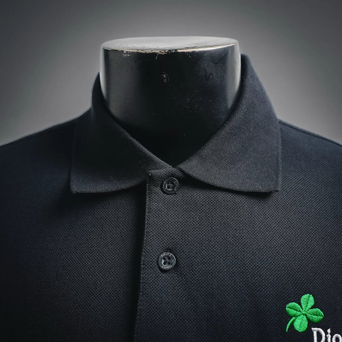 Dior polo shirt close-up: buttoned collar, placket buttons, green clover logo