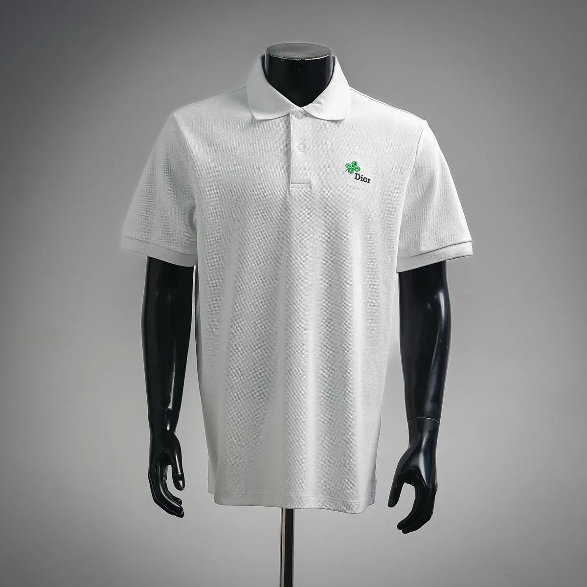 White Dior polo shirt with short sleeves, buttoned collar, green clover Dior logo