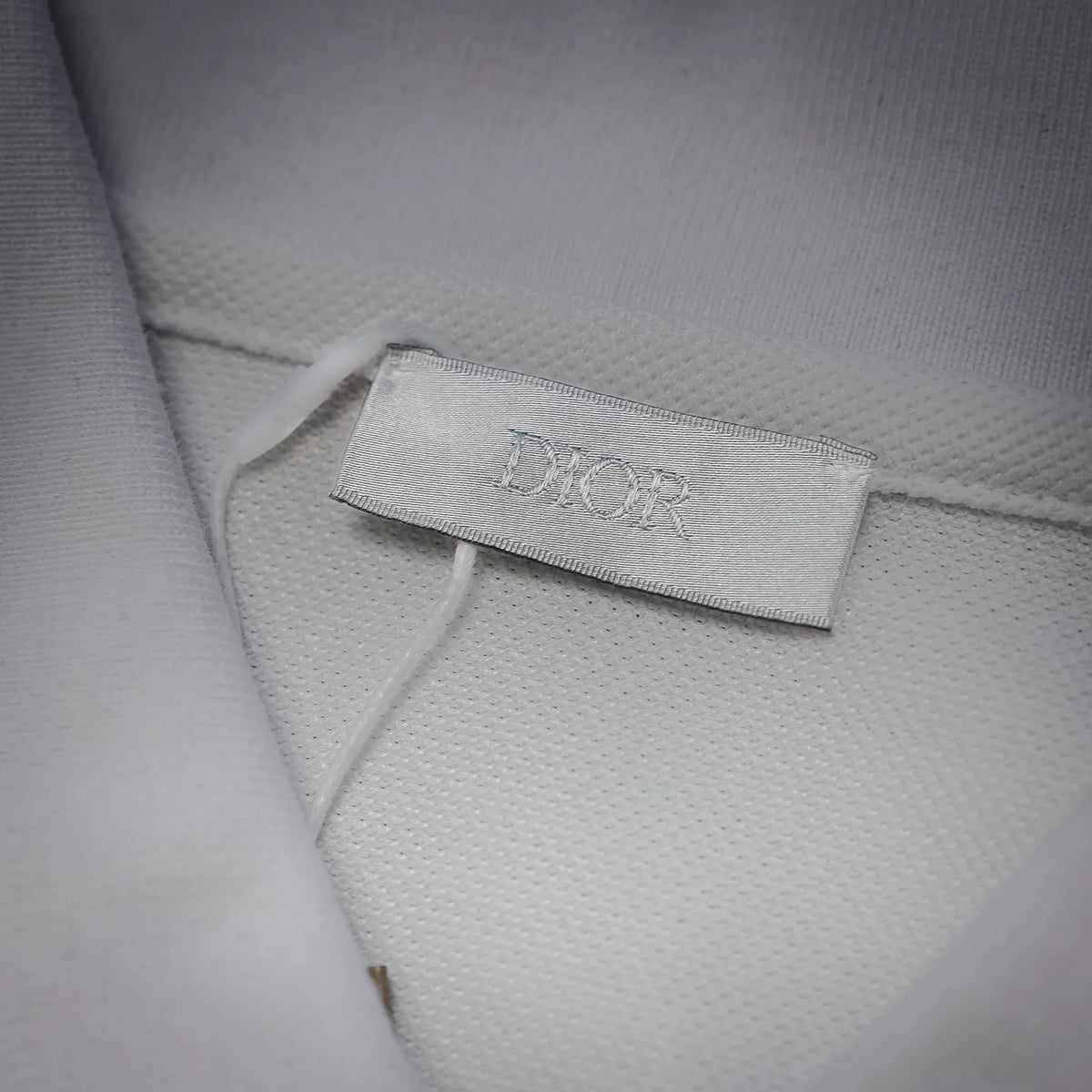 White polo shirt fabric neck label with Dior branding
