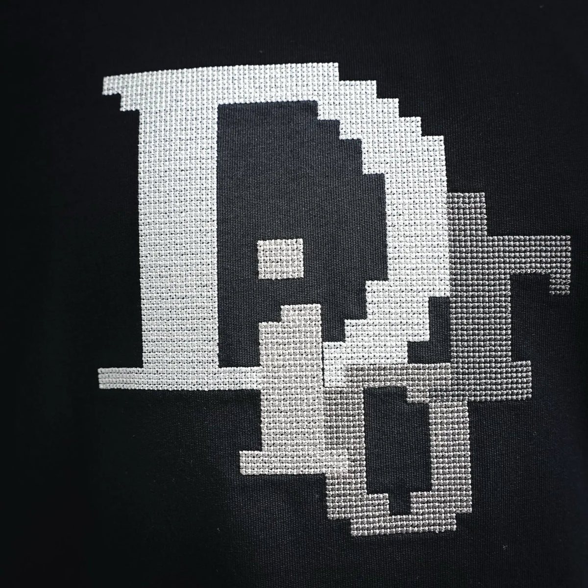 Dior black T-shirt with large white pixel graphic featuring D-like emblem