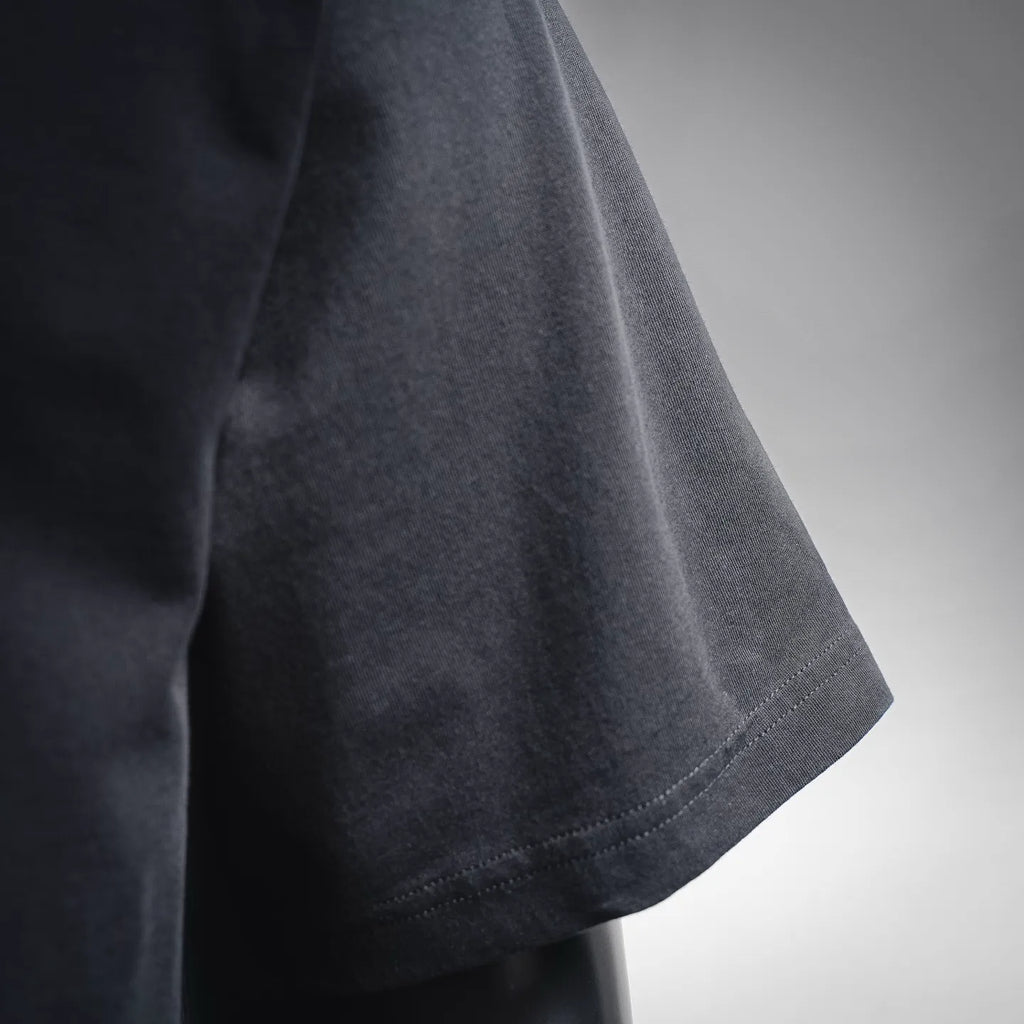 Dior short-sleeve T-shirt sleeve hem close-up, dark fabric and edge stitching