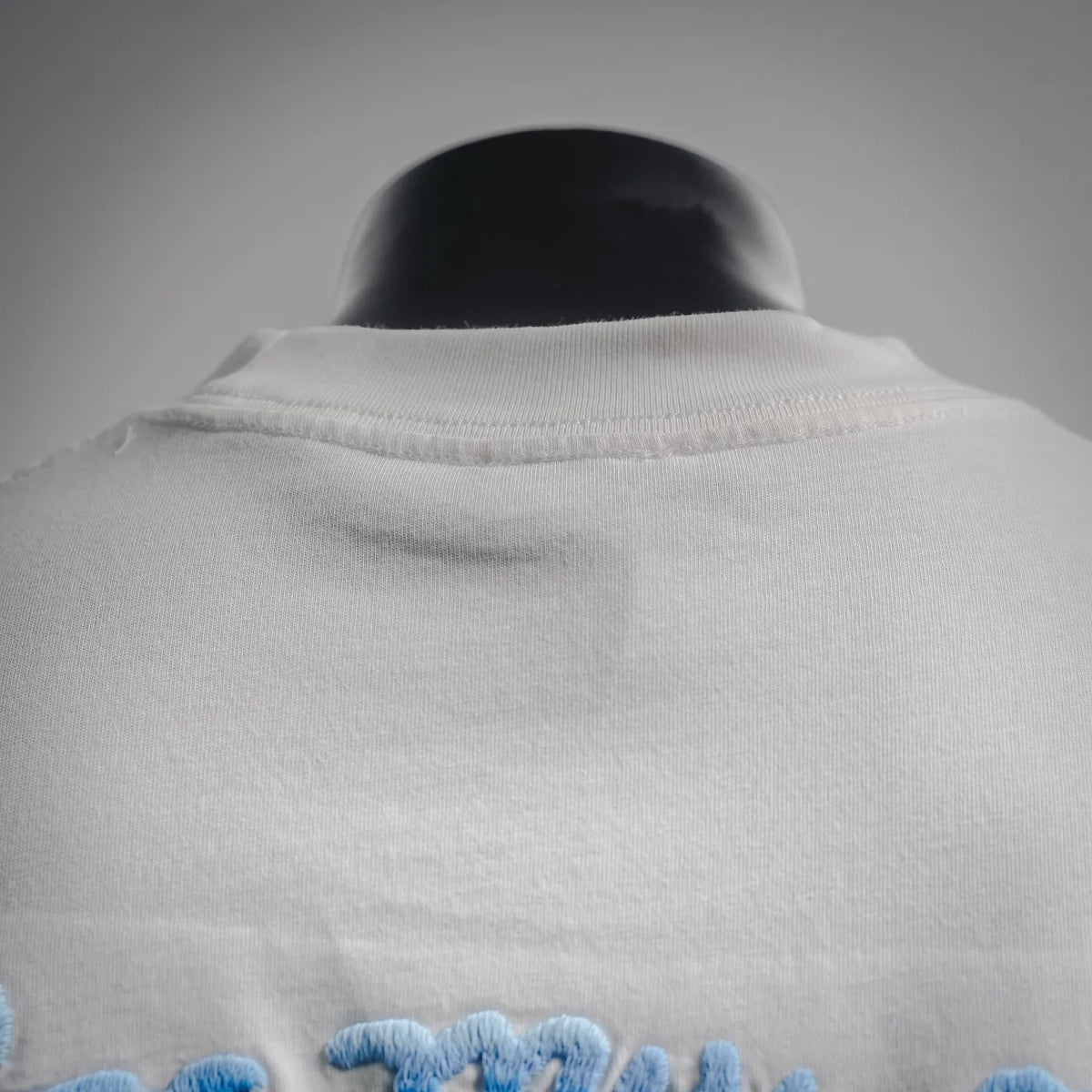 White T-shirt back close-up with ribbed crew neck collar