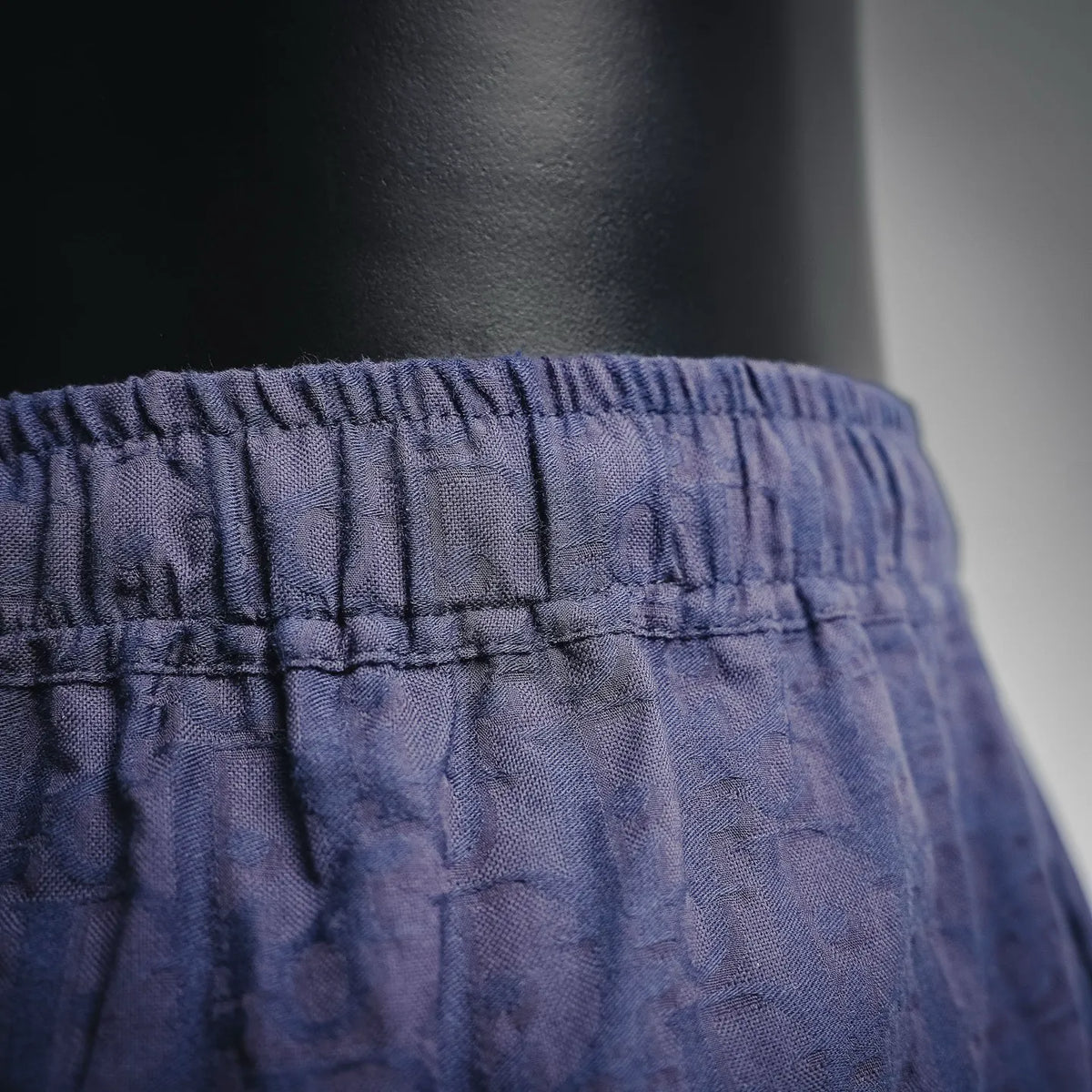 Navy shorts waistband close-up with gathered elastic and stitched panel