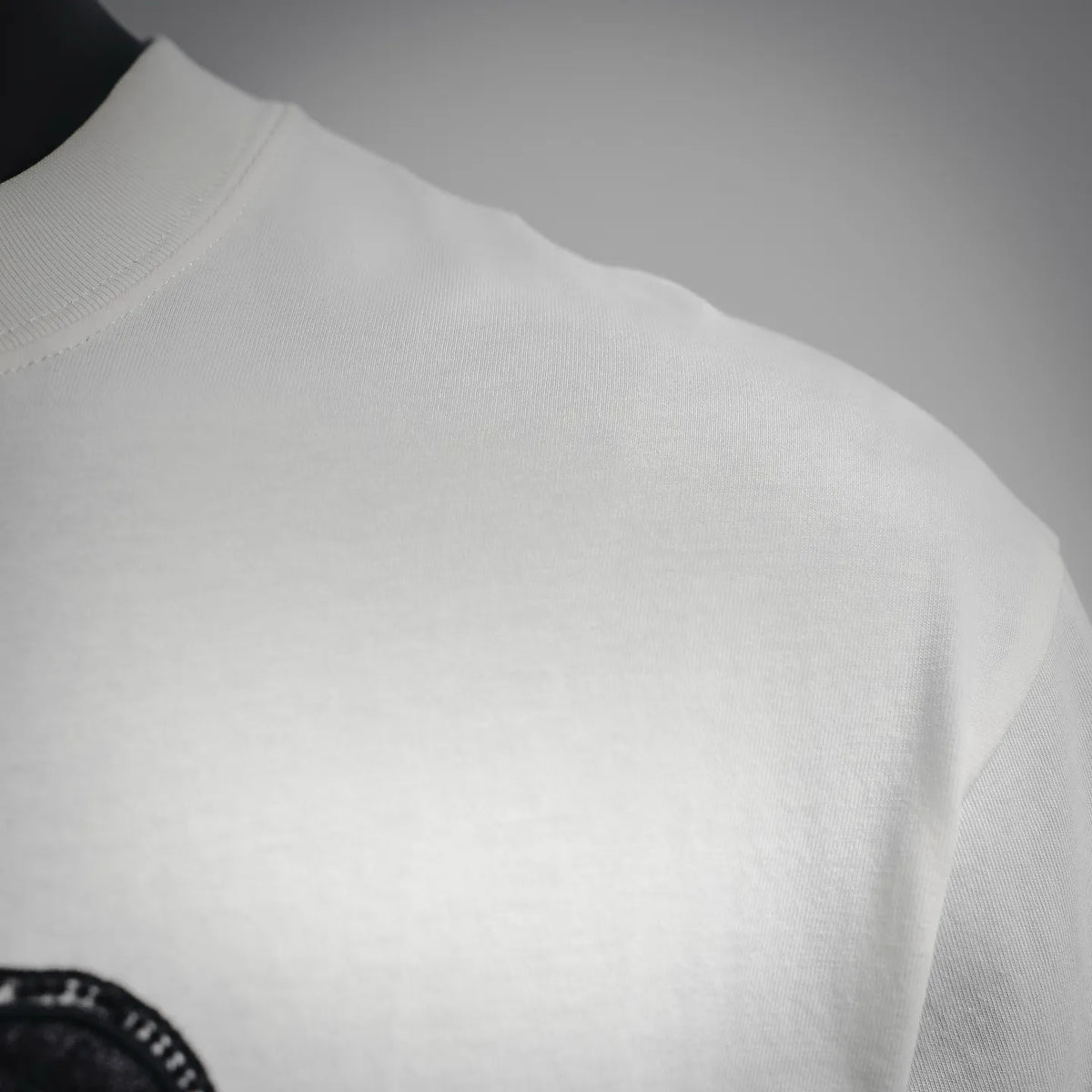 White Dior logo T-shirt side view showing short sleeve hem and stitching