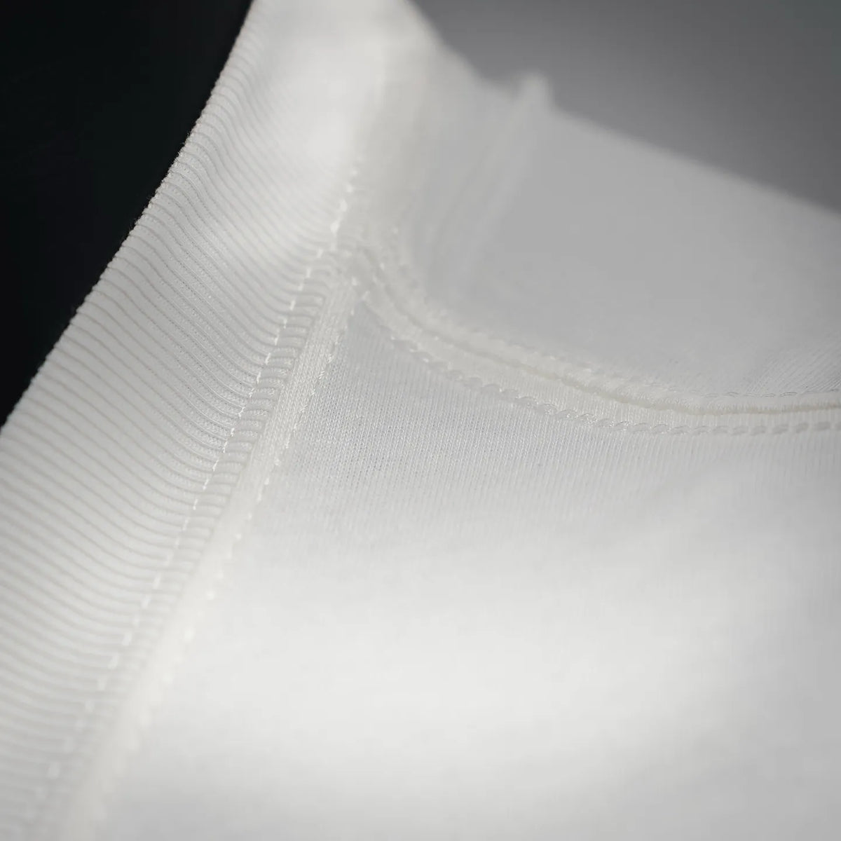 White Dior logo T-shirt collar edge close-up with stitched neckline trim