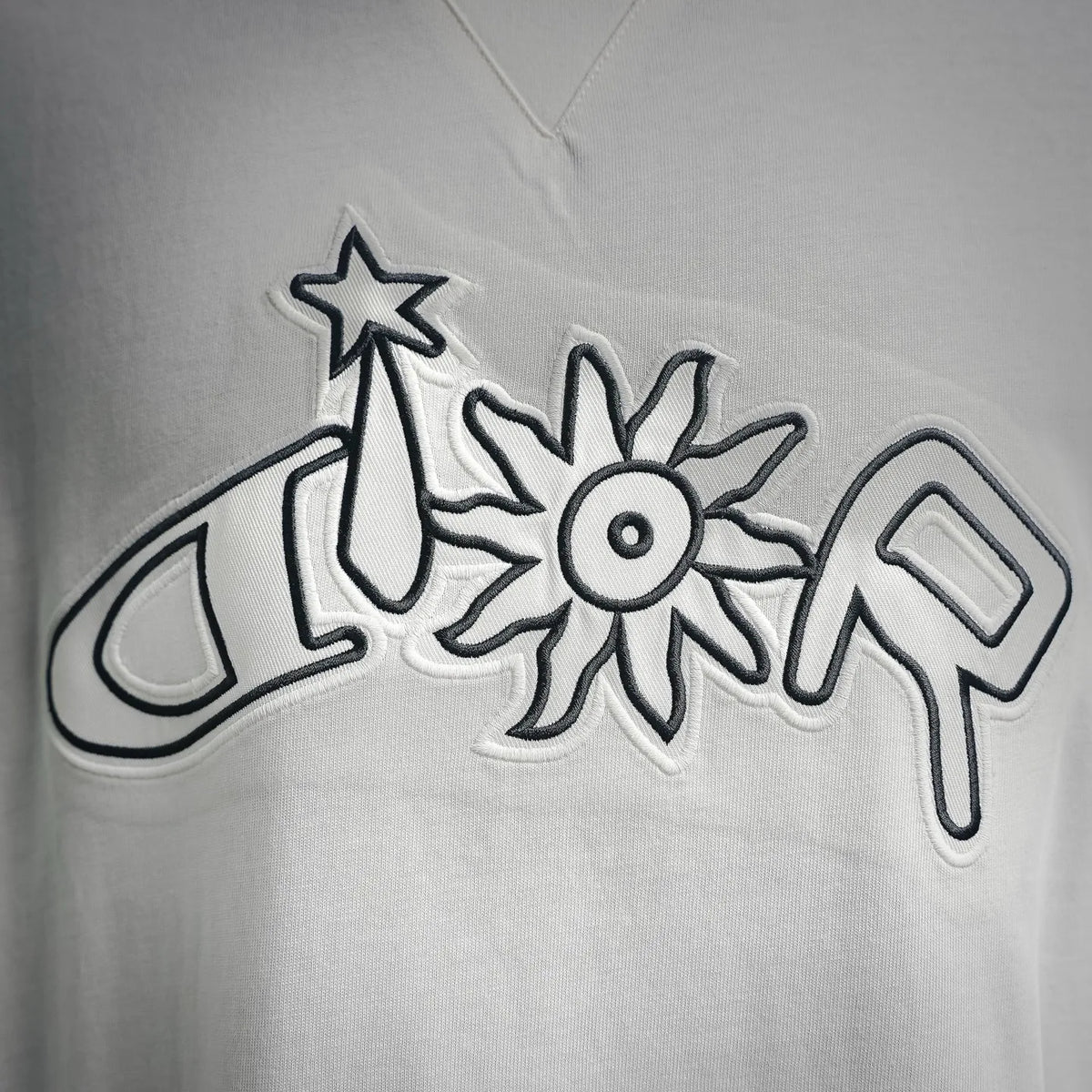 White T-shirt with large black-outlined star and flower graphic