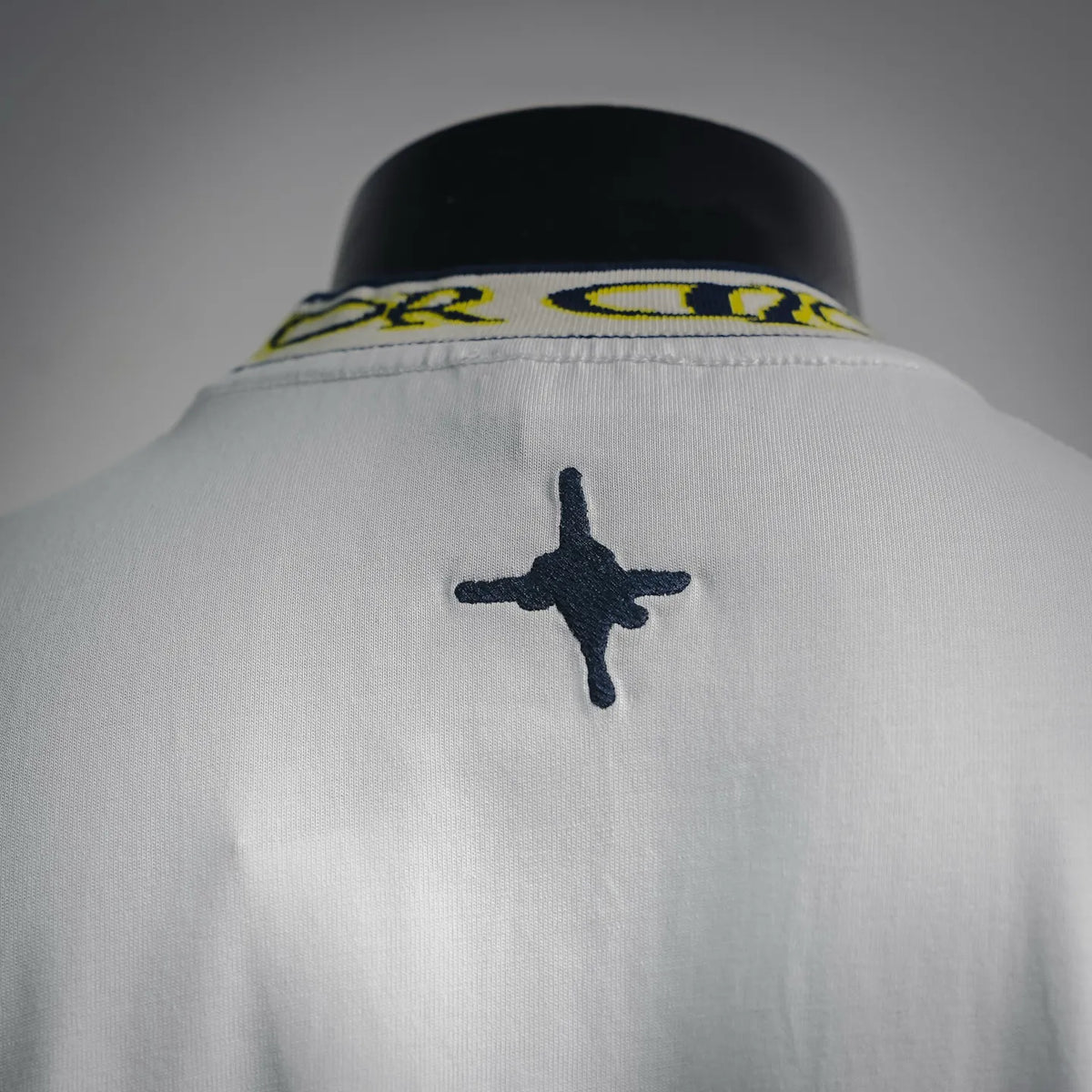 White T-shirt back close-up with navy star graphic below the collar