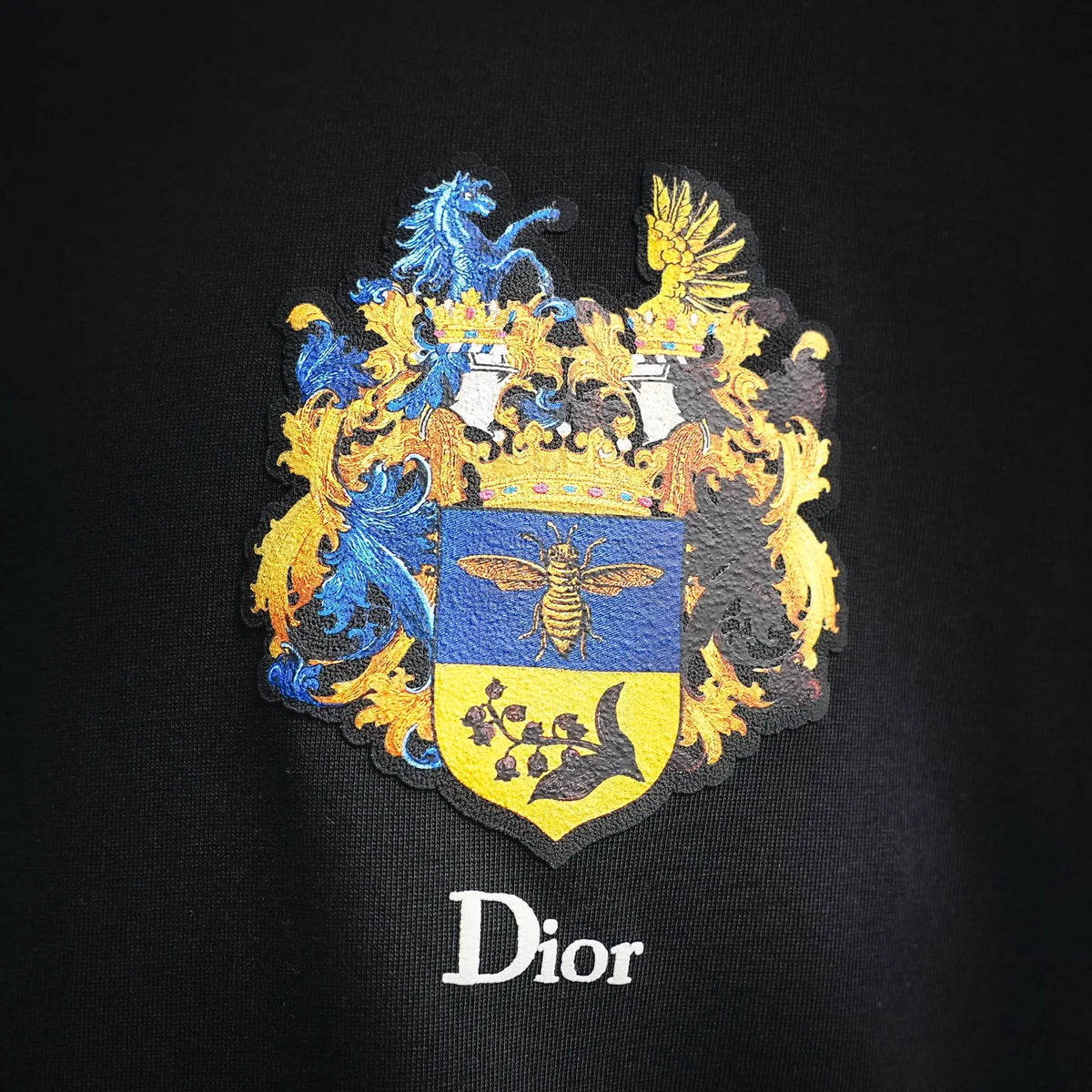 Dior short-sleeve T-shirt, close-up of embroidered coat-of-arms crest and Dior logo