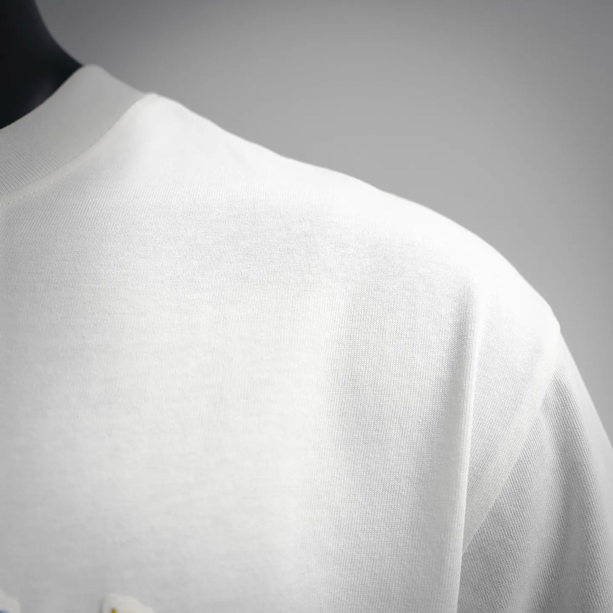 White Dior T-shirt fabric close-up showing smooth knit texture