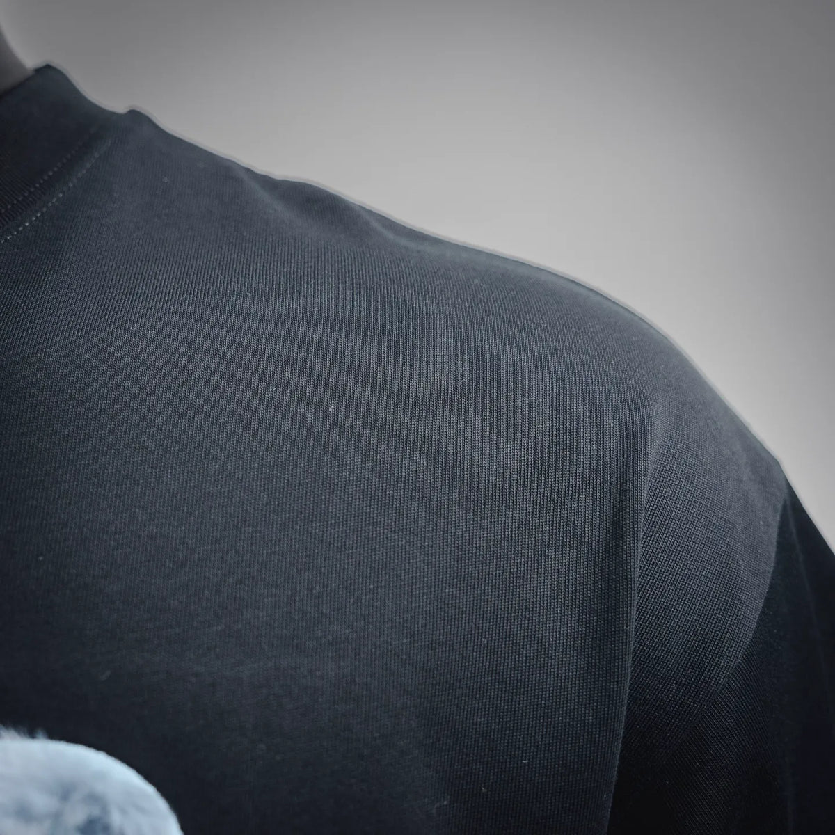 Dior T-shirt fabric close-up with smooth knit texture in dark color