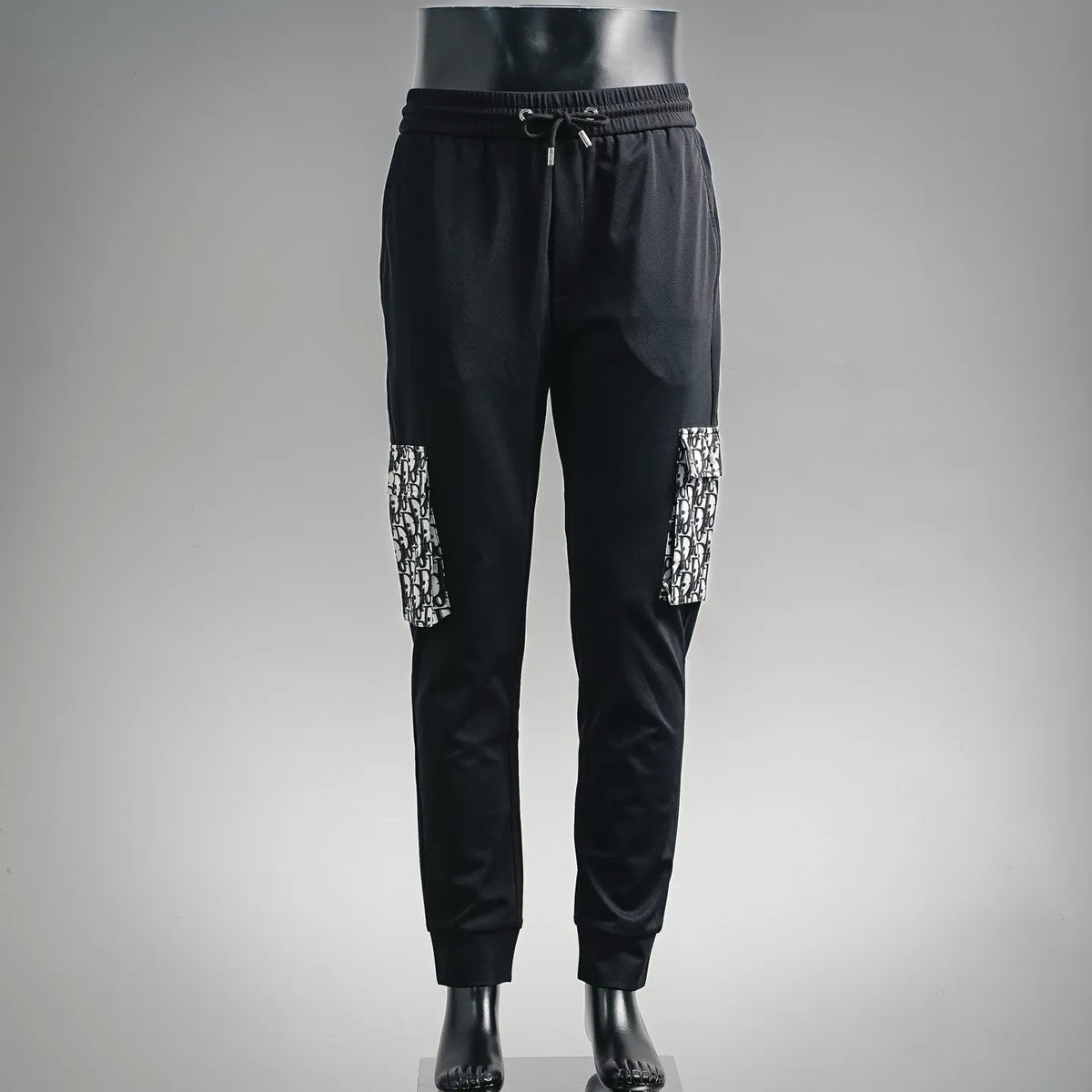 Dior black jogger pants with elastic waistband, drawstring, and monogram-pattern side panels