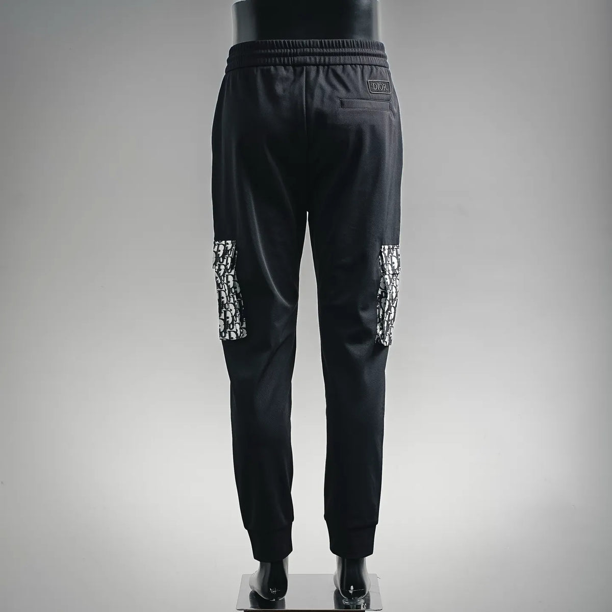 Dior black jogger pants, back view, elastic waist with drawstring and monogram-pattern panel