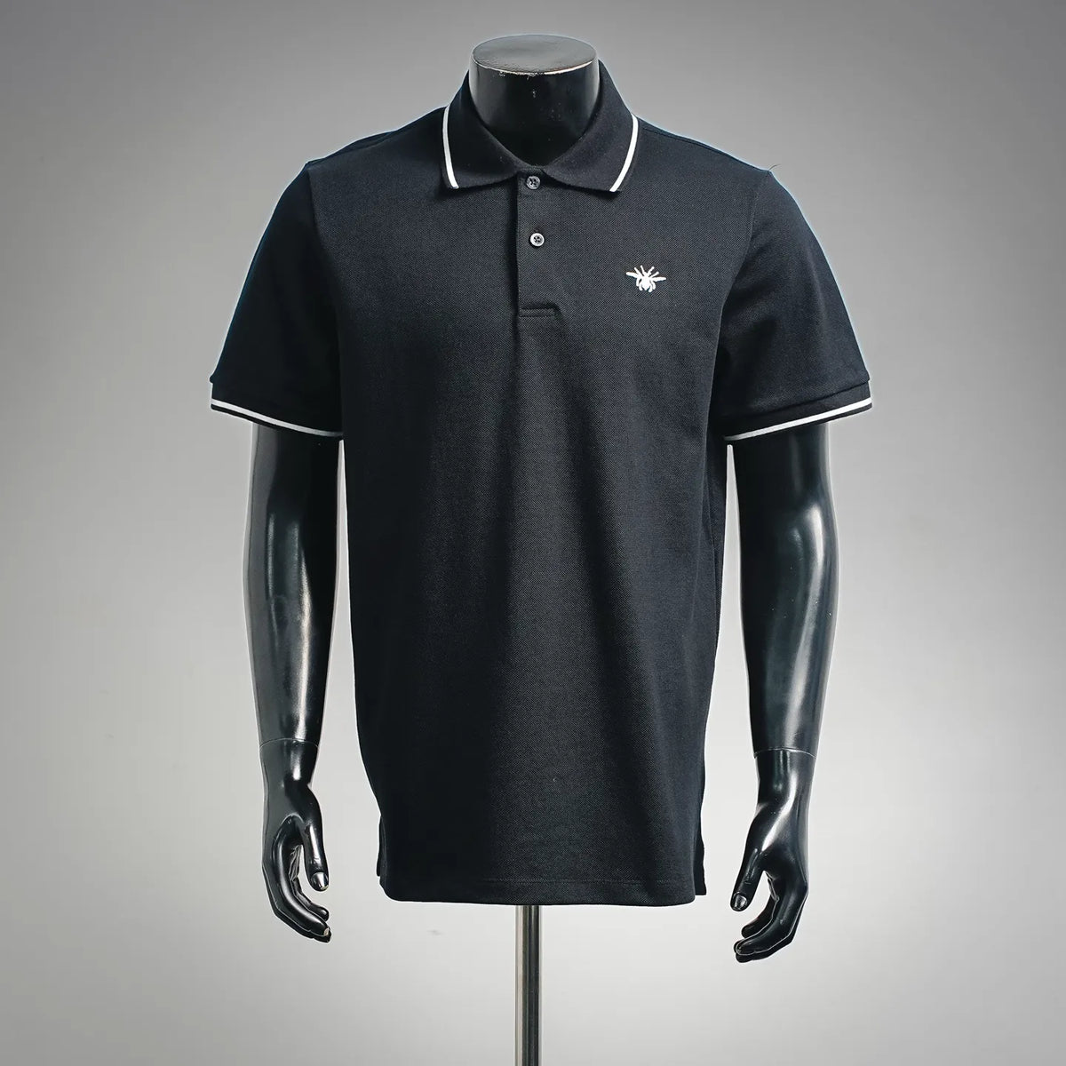 Dior dark polo shirt on mannequin, short sleeves, ribbed collar with white trim, button placket