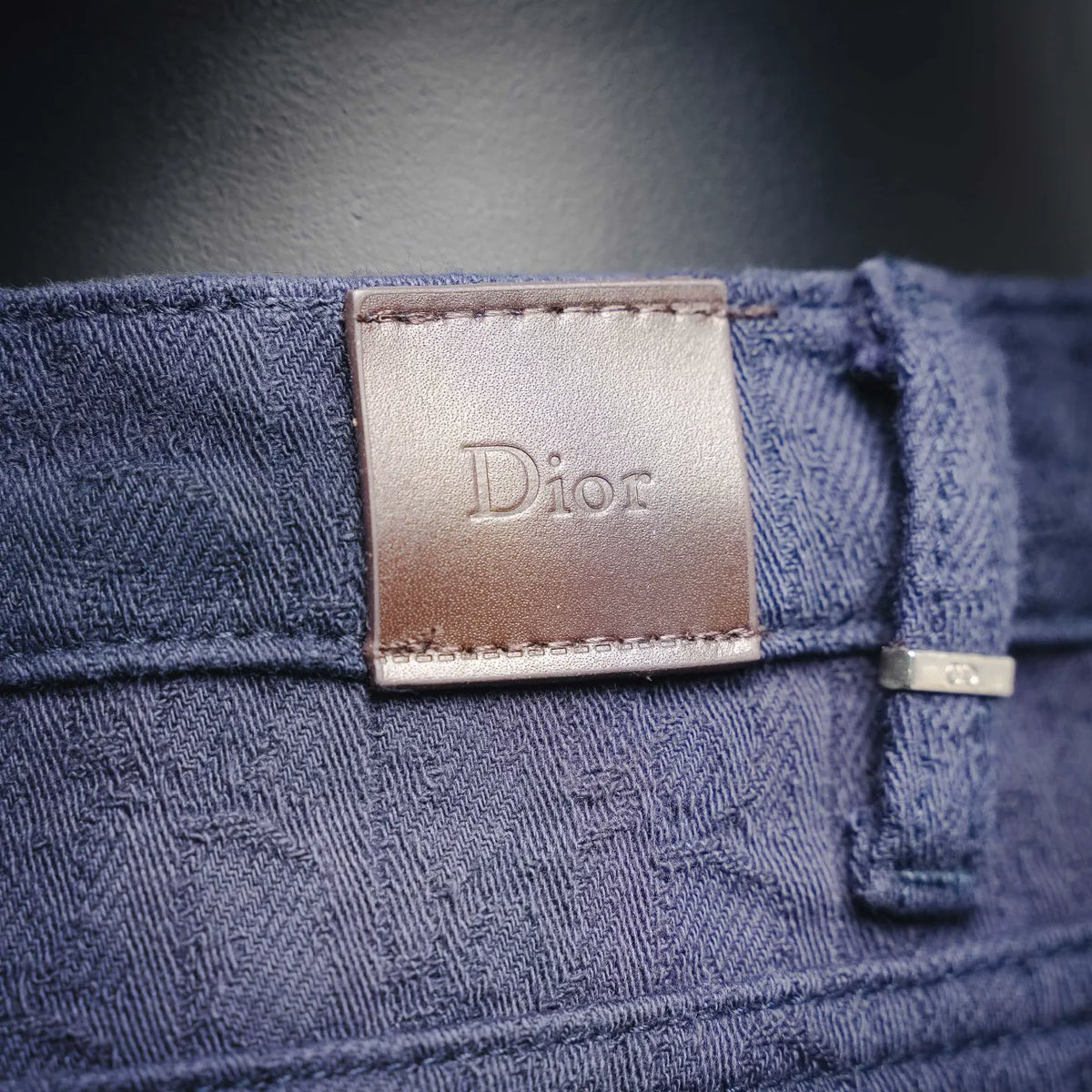 Dark blue Dior denim pants waistband with Dior logo patch and belt tab