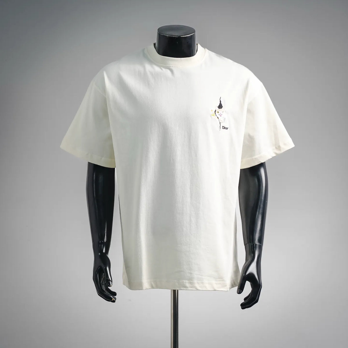 White Dior short-sleeve T-shirt on mannequin with small cat chest logo