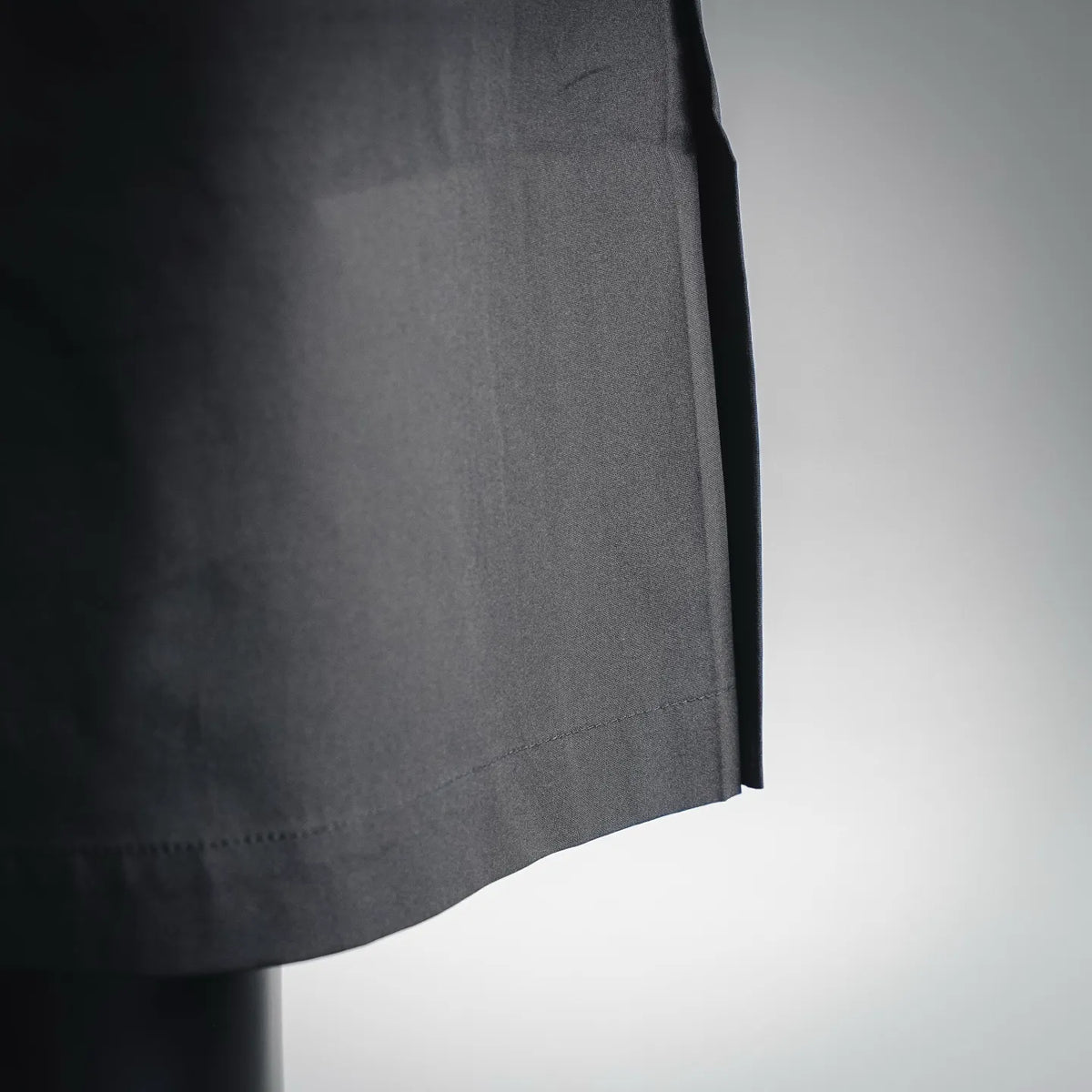 Dark shorts fabric hem with clean stitching and side seam detail