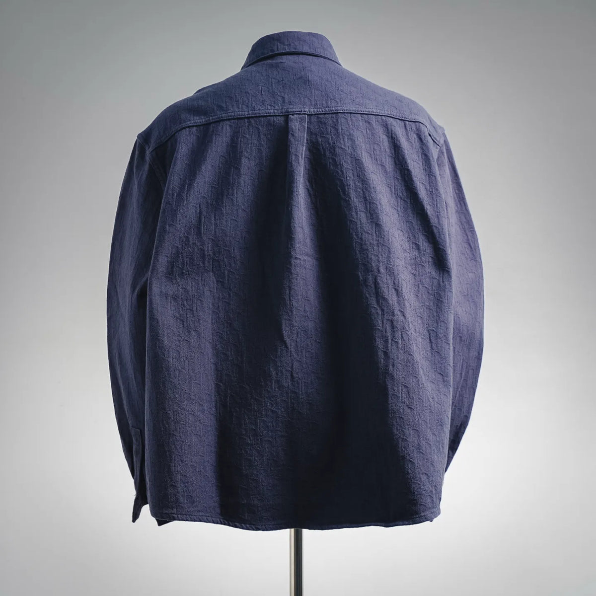 Dior long-sleeve button-up shirt, back view, dark navy textured fabric, curved hem