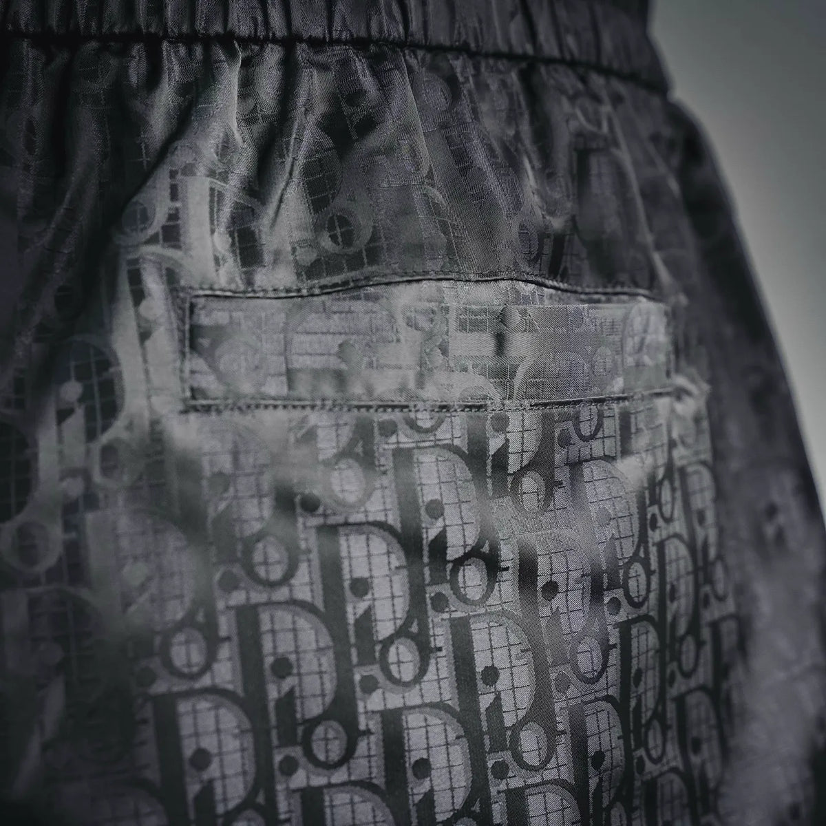 Dior shorts fabric close-up with elastic waistband and textured graphic pattern