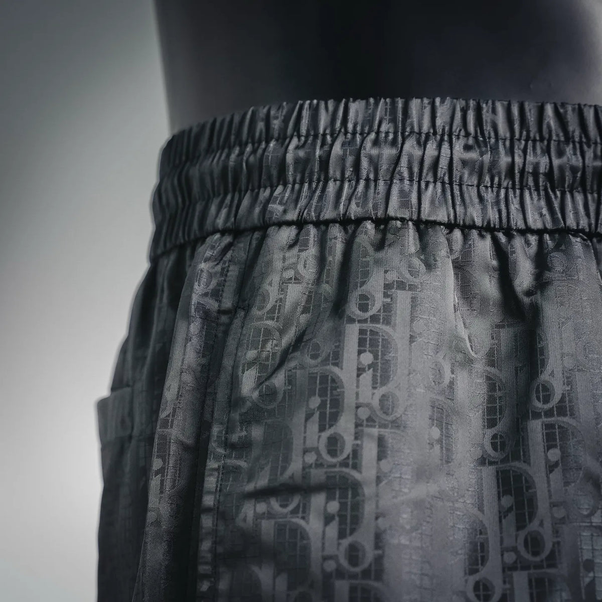Dior shorts waistband close-up with elastic band and signature-style print