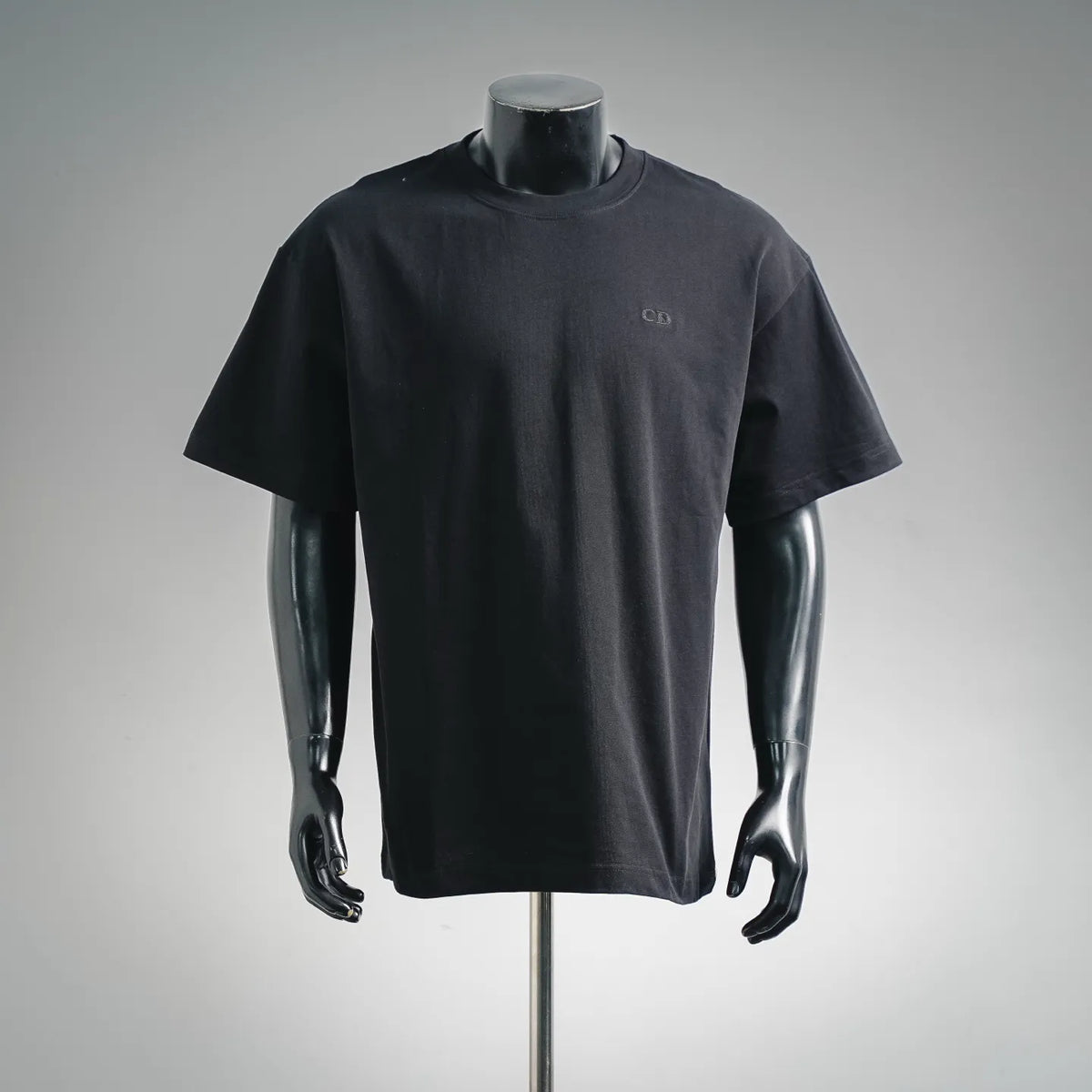 Dior short-sleeve T-shirt on mannequin, dark gray crew neck with small CD logo