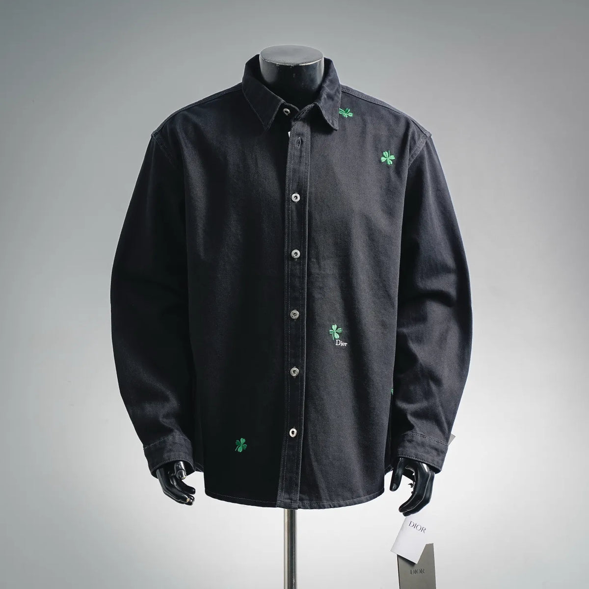 Black long-sleeve button-up shirt with green clover embroidery on chest and pocket