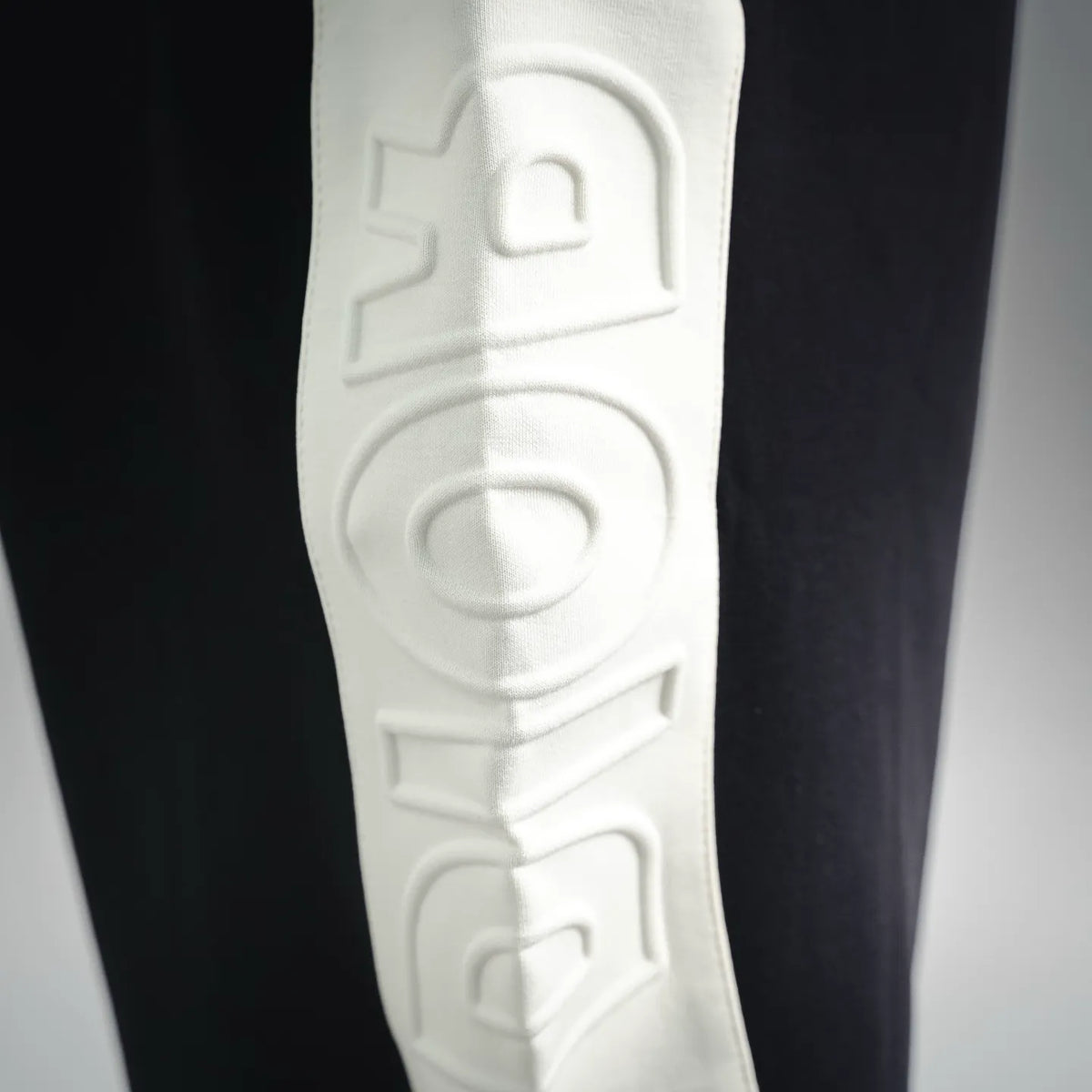 Black shorts with embossed white vertical lettering logo on the side panel