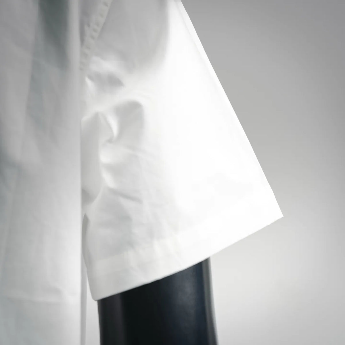 White short-sleeve button-up shirt sleeve with side seam detail