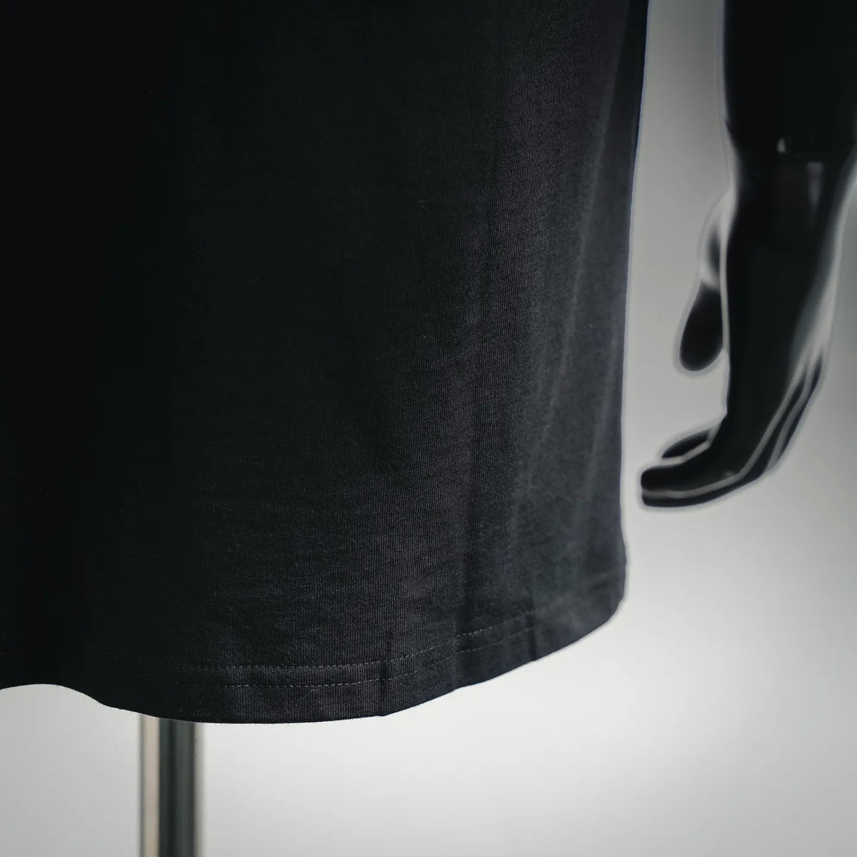 Black T-shirt hem with double-stitch detail at bottom edge