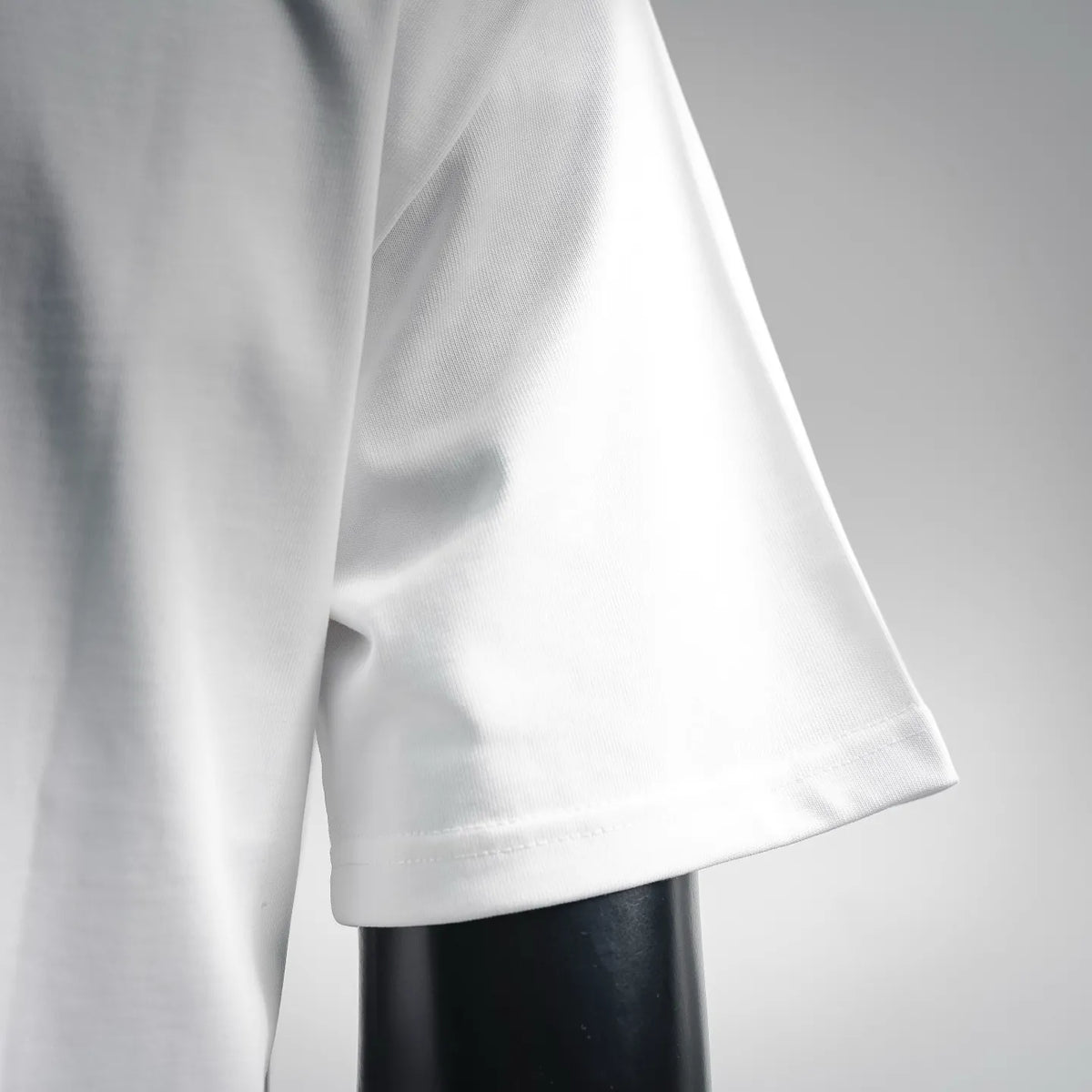 White short-sleeve T-shirt sleeve and curved hem detail on mannequin