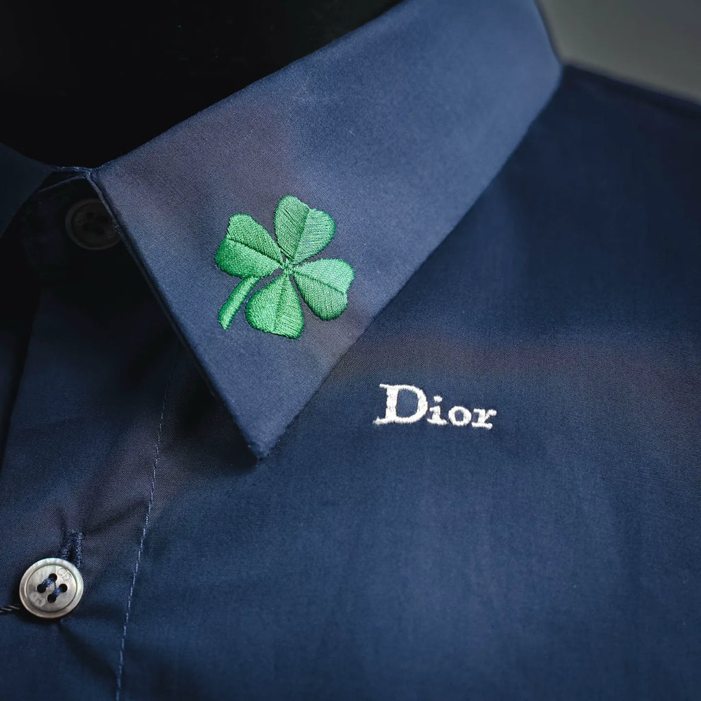 Dior dark blue shirt with pointed collar, green clover patch, and Dior logo embroidery