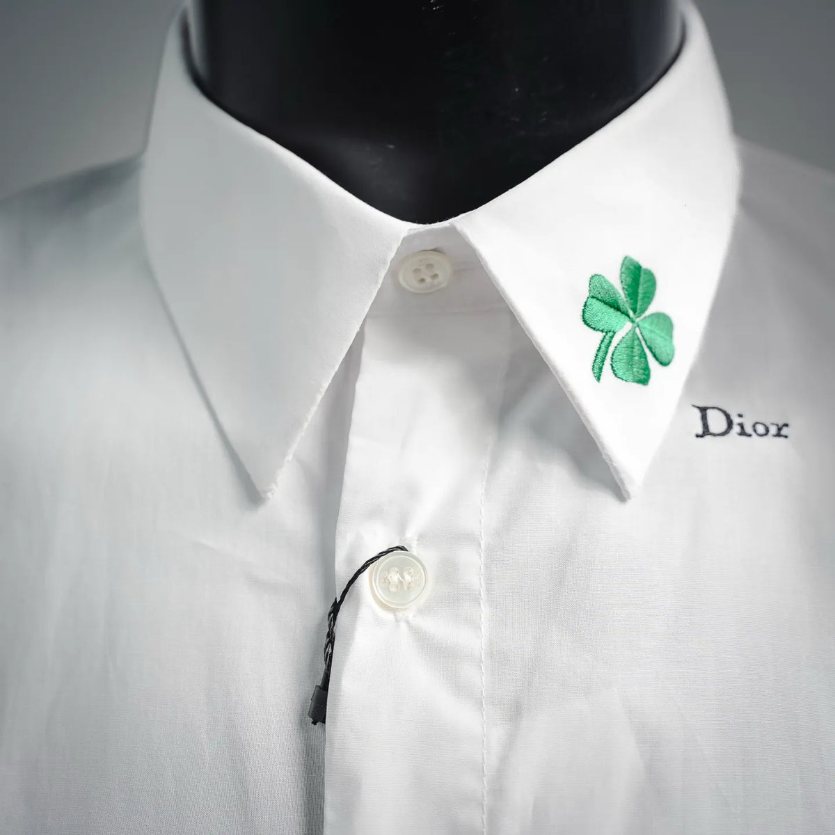 White short-sleeve shirt collar with green clover patch and Dior logo