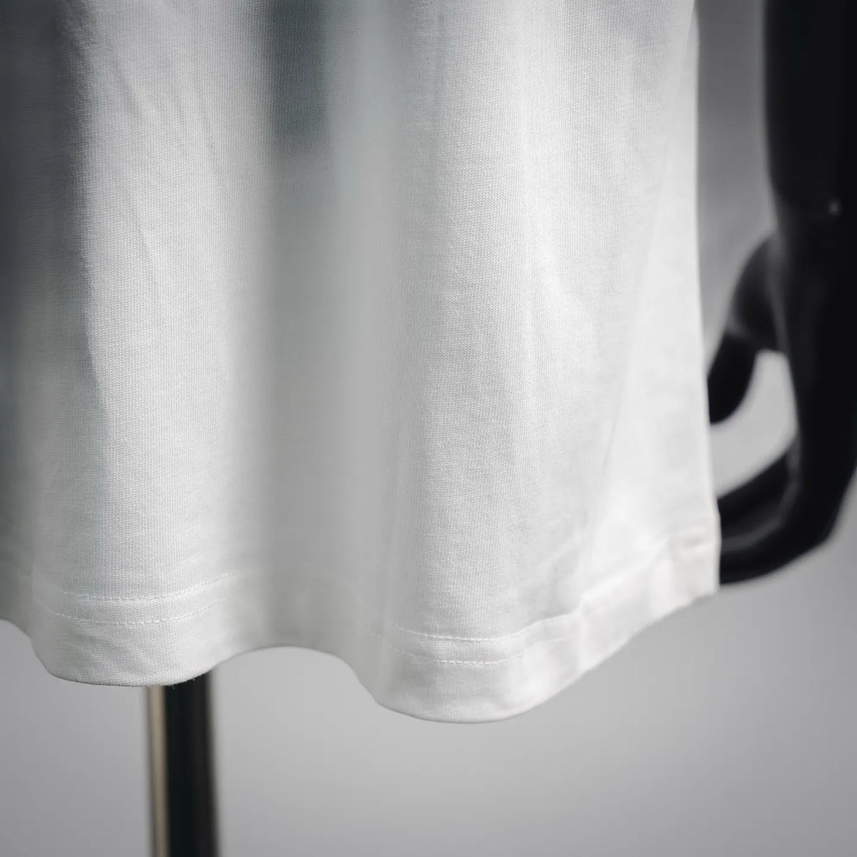 White short-sleeve T-shirt hem with visible stitching