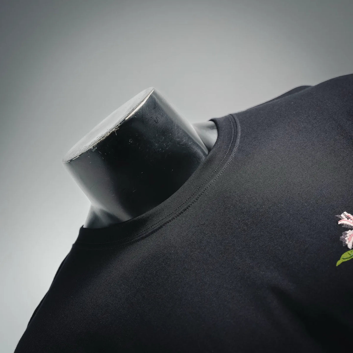 Black Dior T-shirt with embroidered floral accent near the shoulder