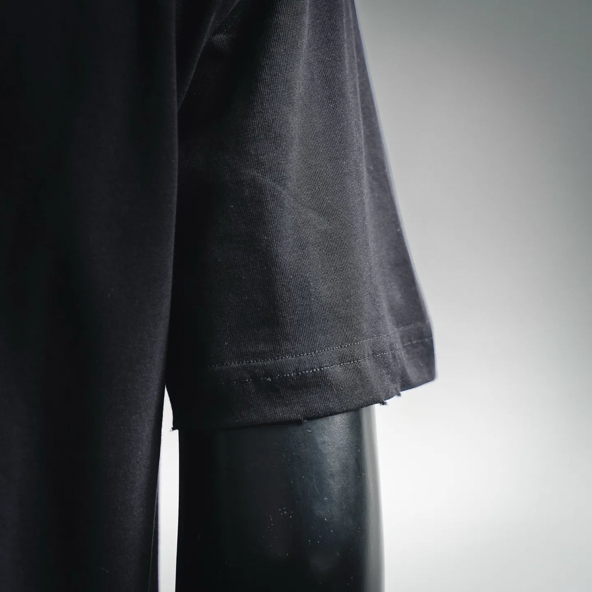 Black Christian Dior T-shirt fabric and lower front close-up, short sleeves