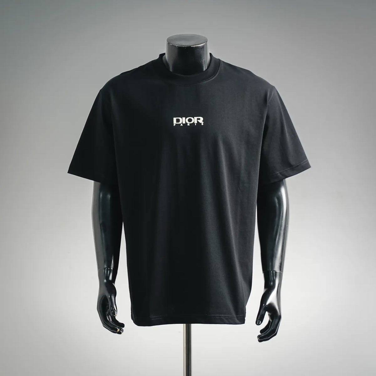 Dior short-sleeve T-shirt on mannequin, front crew neck with small DIOR logo center.