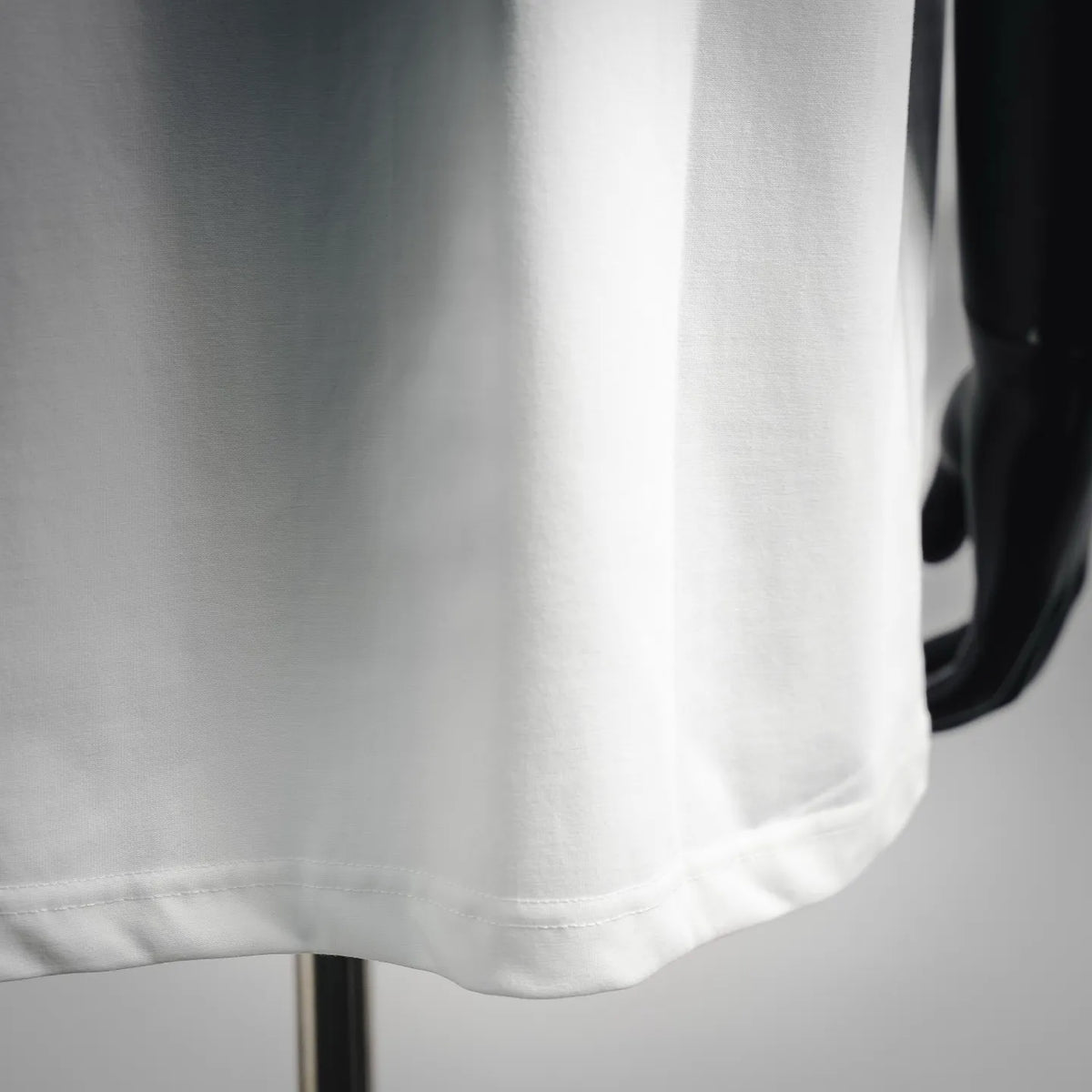 White T-shirt hem close-up with smooth cotton fabric