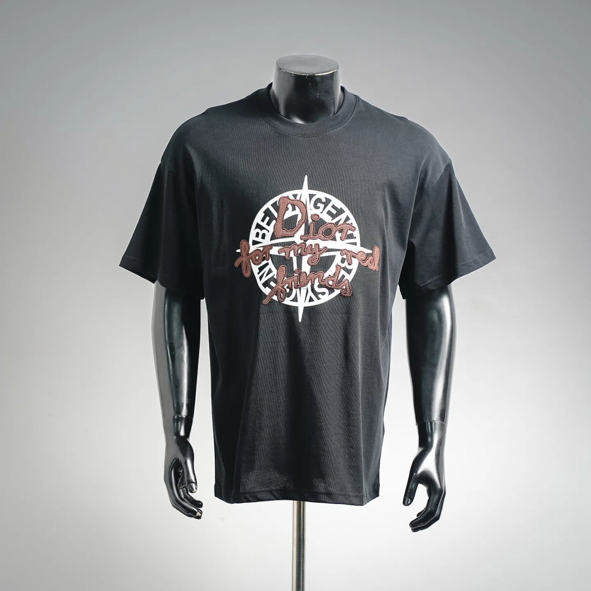Black short-sleeve T-shirt on mannequin, front graphic logo patch in brown and white