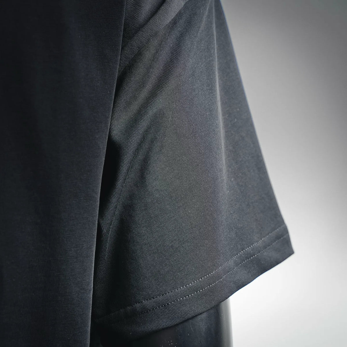Black short-sleeve T-shirt side seam and cuff stitching close-up