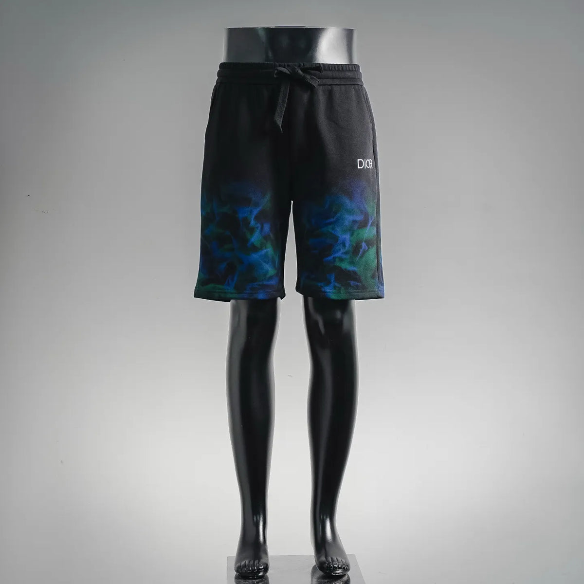 Black Dior drawstring shorts with blue-green graphic print on the legs