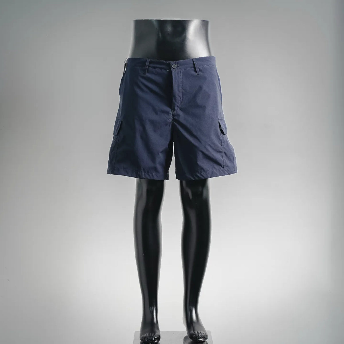 Navy cargo shorts on a mannequin, front button and zip closure, side pockets