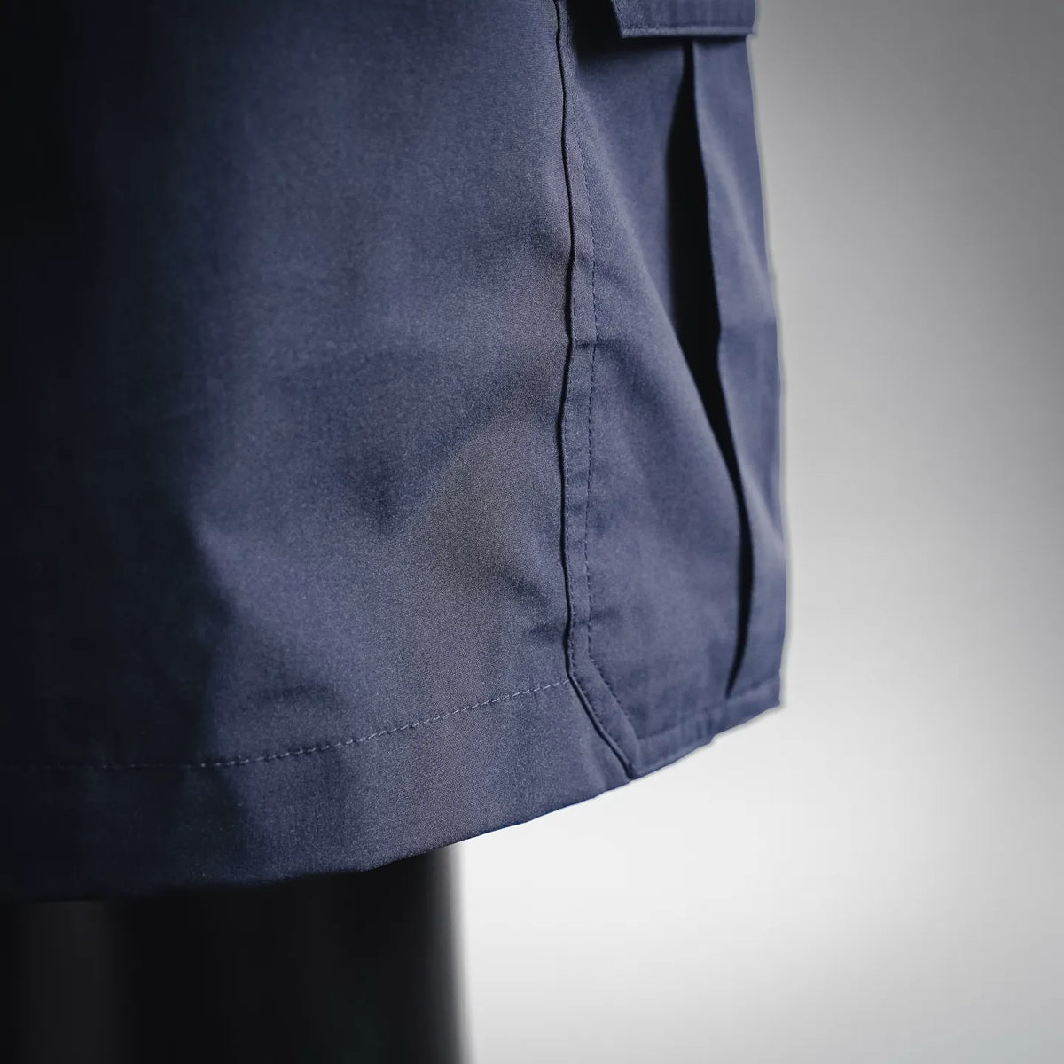 Close-up of navy cargo shorts fabric and hem seam detail
