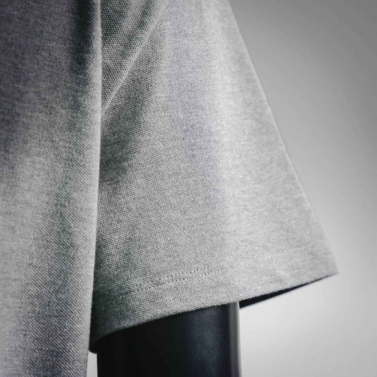 Gray heather polo fabric close-up with short sleeve hem