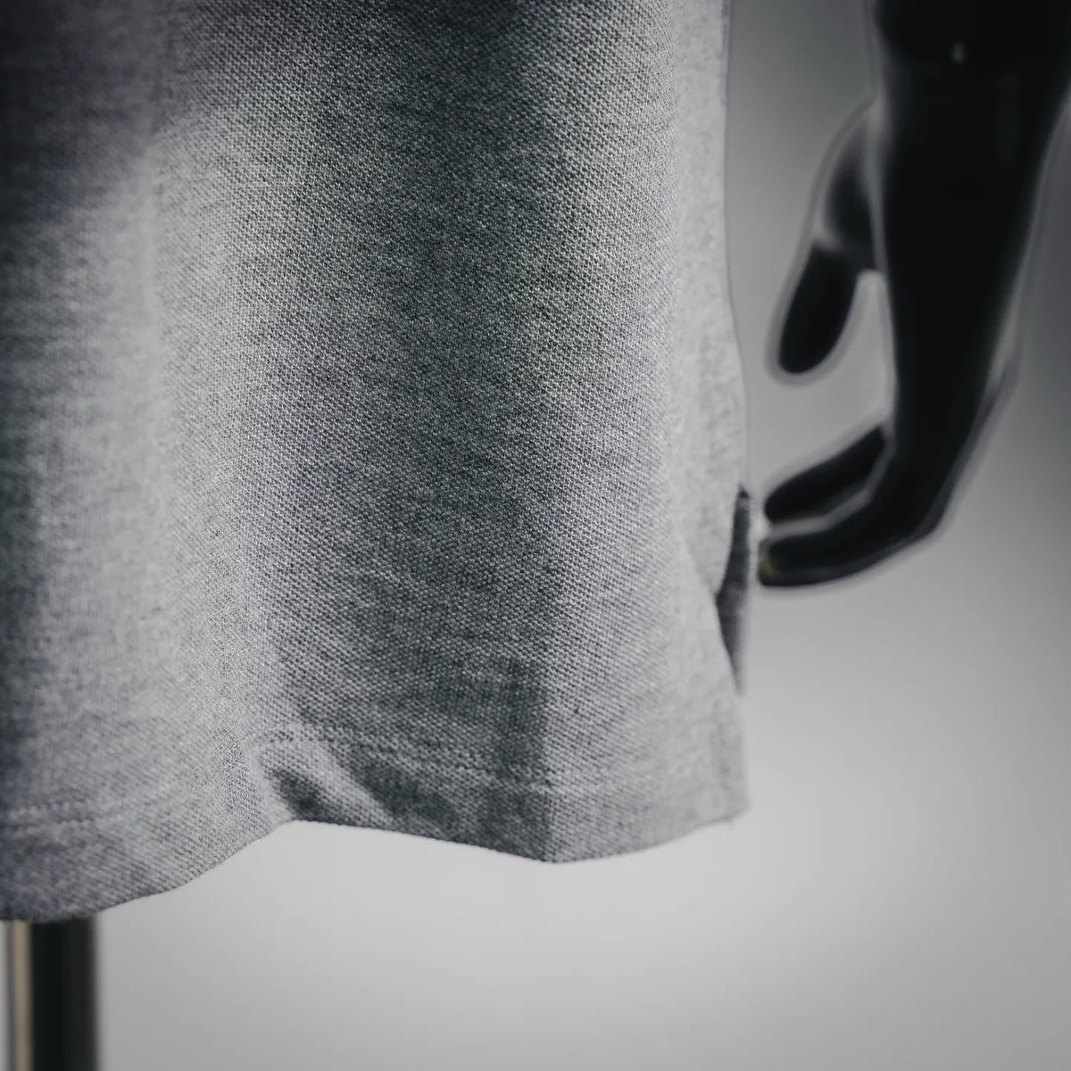 Gray heather polo shirt side hem close-up